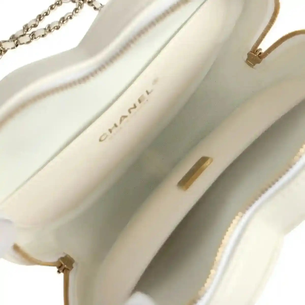 White interior lining close-up with Chanel label and gold-tone hardware accents