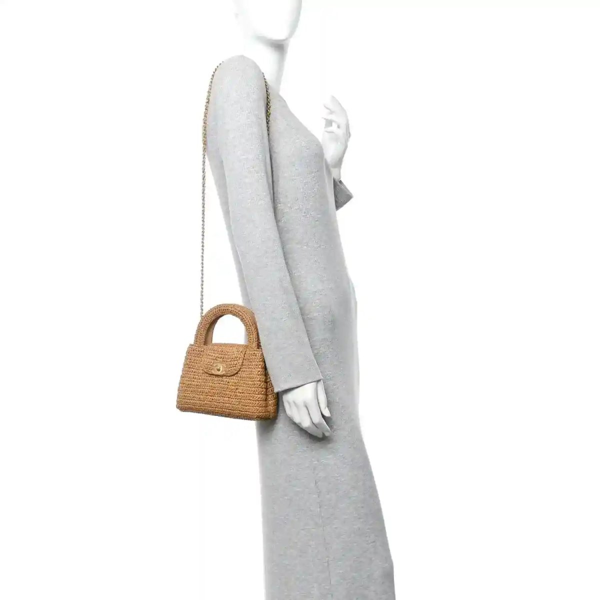Dark beige raffia nano bag with short handle and long chain strap worn by model