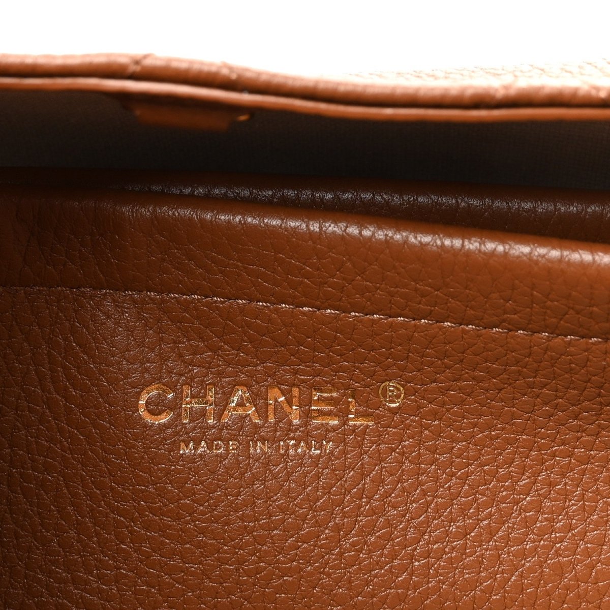 Chanel stamp on camel brown grained leather panel, with “Made in Italy” text.