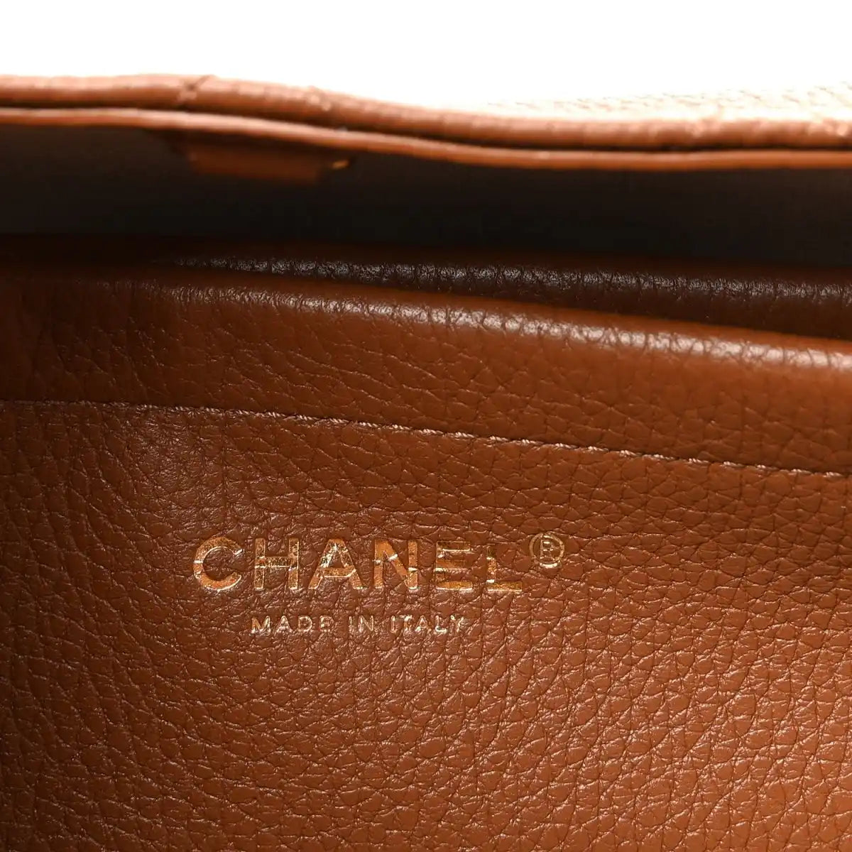 Chanel stamp on camel brown grained leather panel, with “Made in Italy” text.