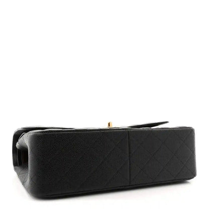 Chanel double flap bag side view in black quilted leather with gold clasp