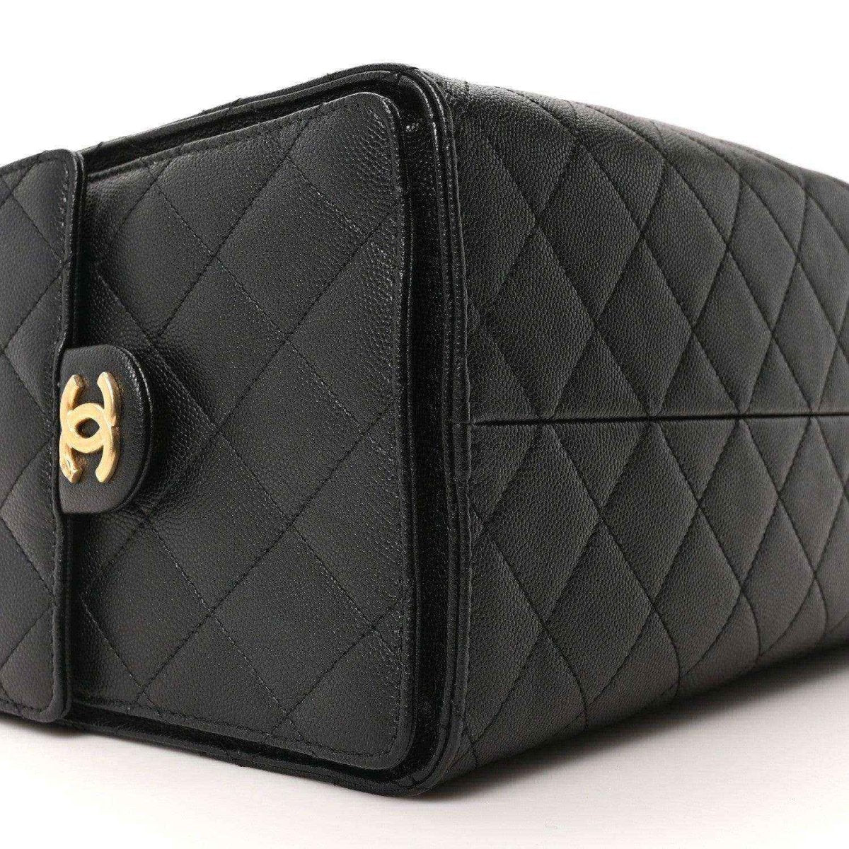 Black quilted leather handbag side panel with gold Chanel turn-lock detail