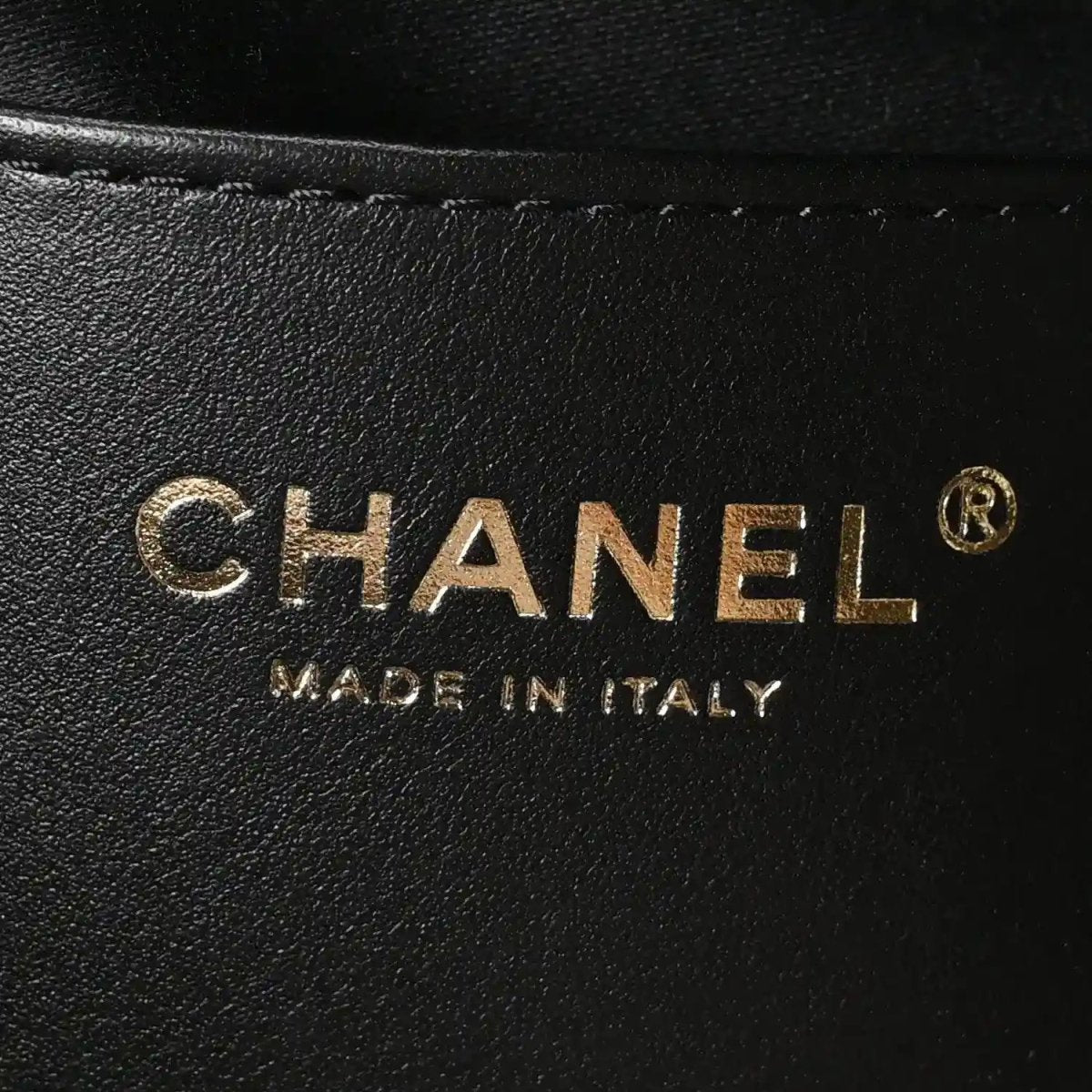 Chanel logo stamp on black leather handbag