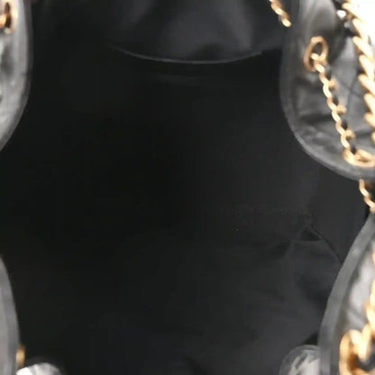 Black leather handbag interior opening with gold chain hardware