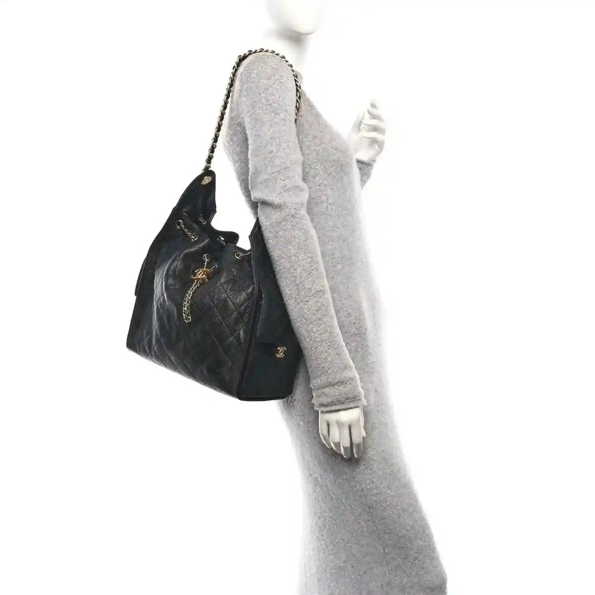 Black quilted leather handbag with gold chain strap shown from side