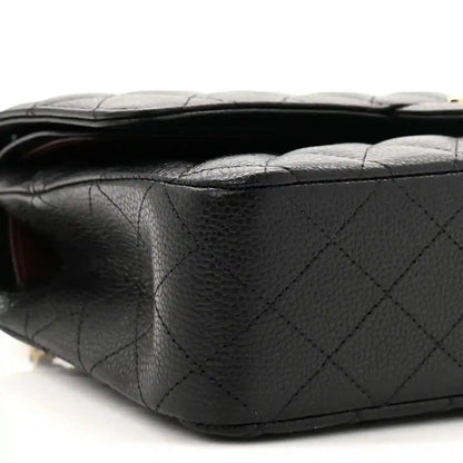 Black quilted caviar leather flap bag side profile with stitched panels