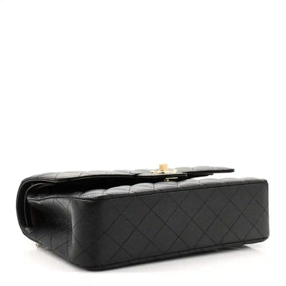 Black caviar leather flap bag underside with gold-tone clasp hardware