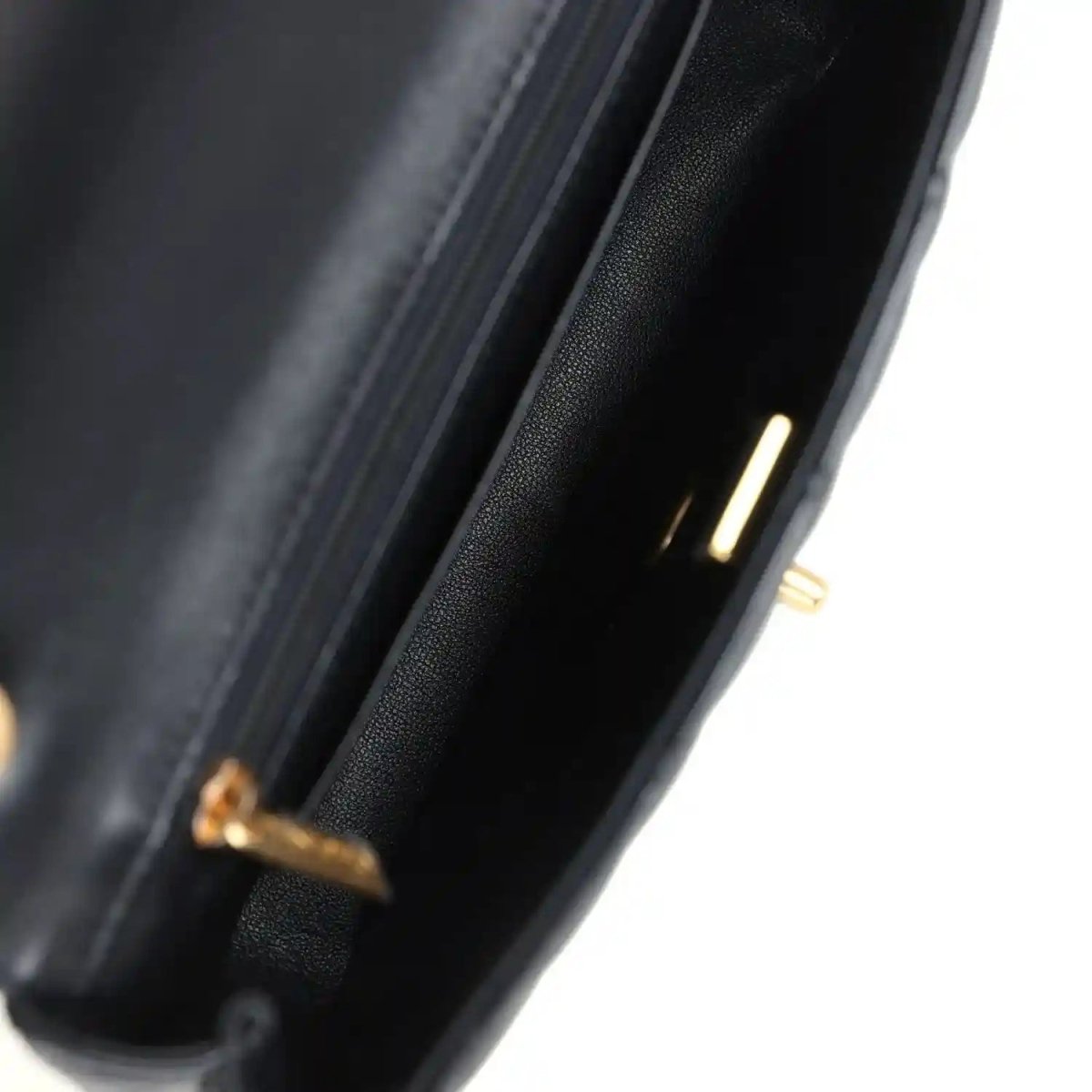 Black lambskin flap bag interior opening edge with gold hardware accent detail