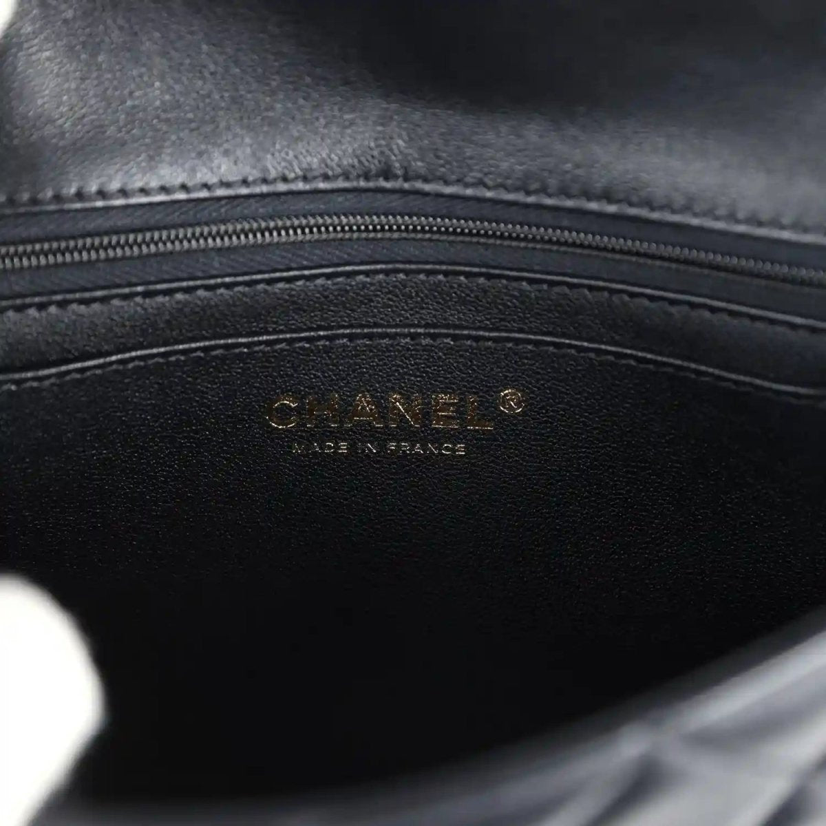 Black lambskin mini flap bag interior with Chanel logo stamp