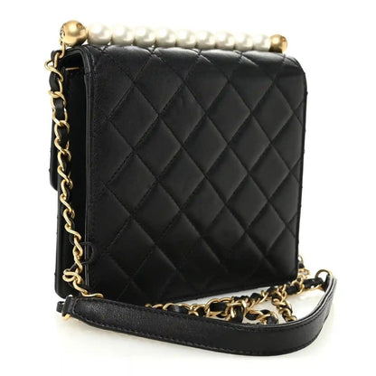 Chanel black quilted leather flap bag with gold-tone chain and faux pearl top accents