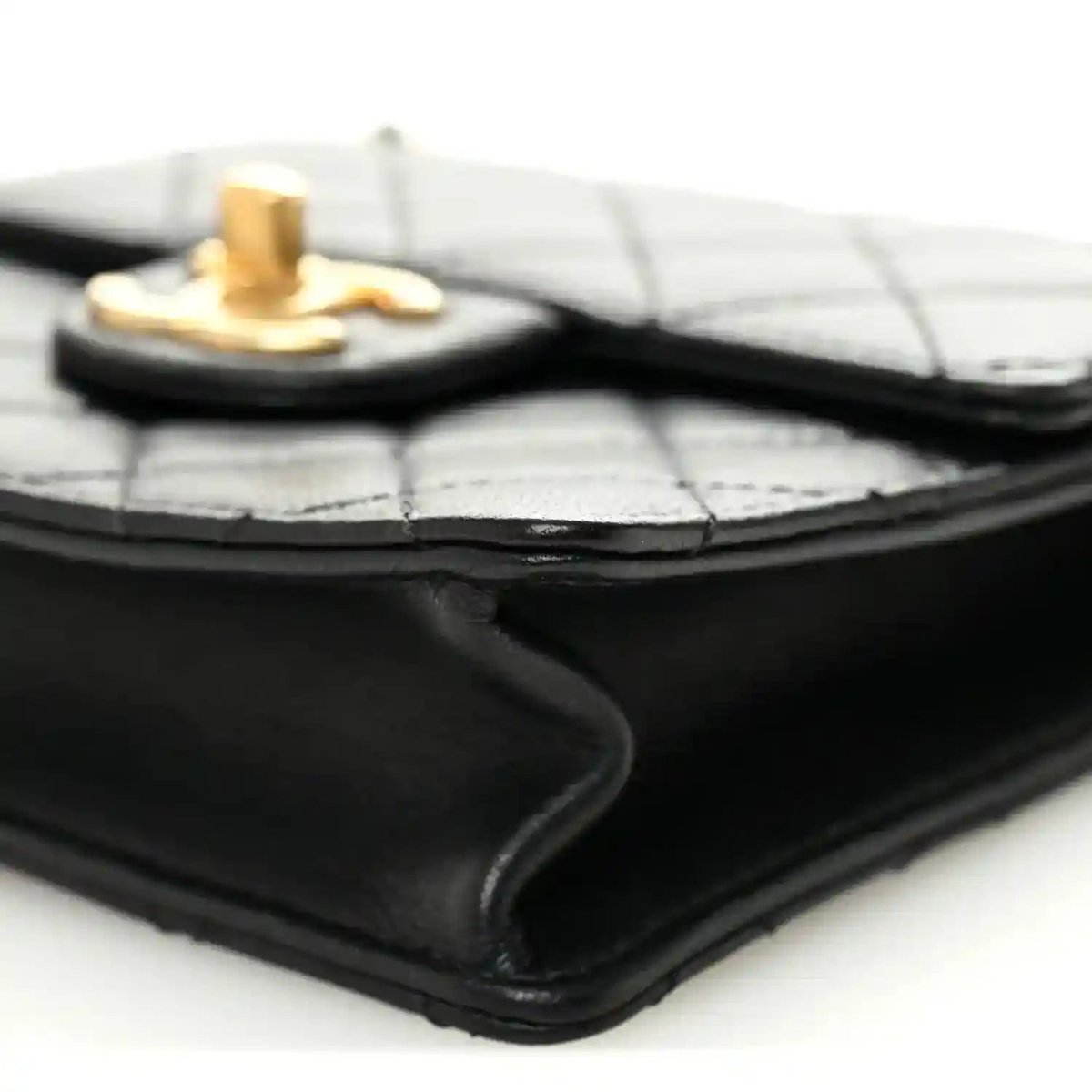 Chanel black quilted flap bag corner close-up with gold-tone top hardware