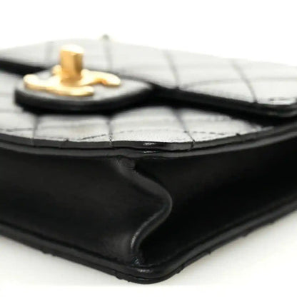 Chanel black quilted flap bag corner close-up with gold-tone top hardware
