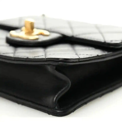 Chanel black quilted flap bag corner close-up with gold-tone top hardware