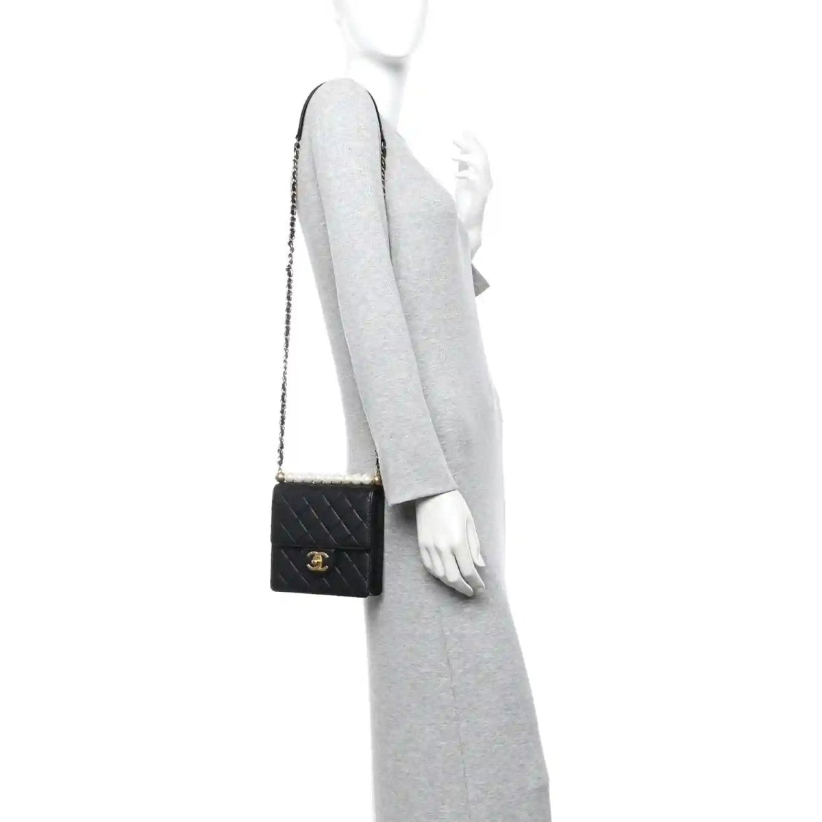 Chanel black quilted flap crossbody bag worn on a model with gold-tone chain strap