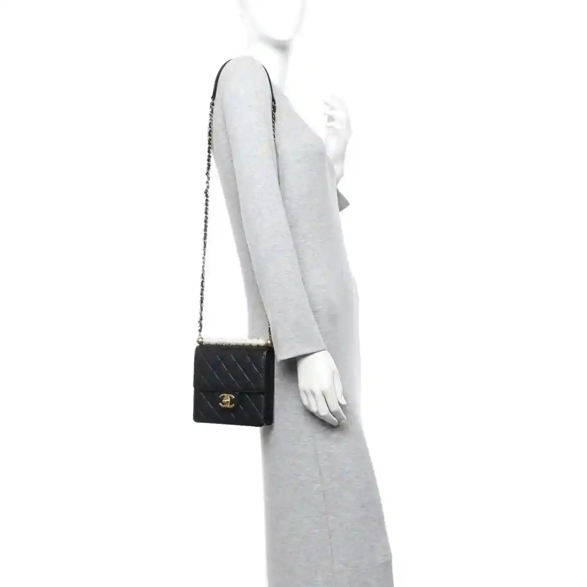 Chanel black quilted flap crossbody bag worn on a model with gold-tone chain strap