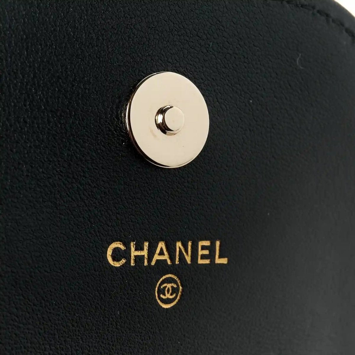 CHANEL logo snap button on black leather clutch
