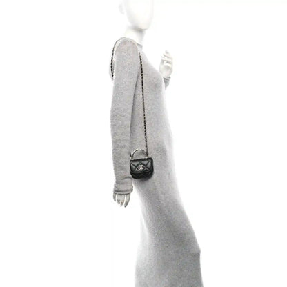 Small black quilted leather clutch with chain strap, shown worn