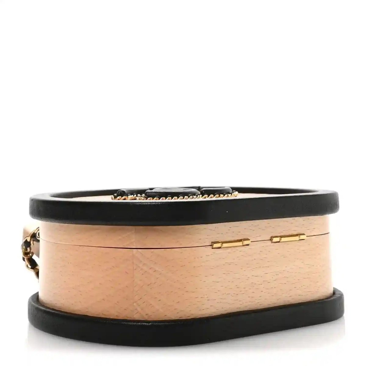 Chanel vanity case top band with black leather trim and slim gold clasp on light wood