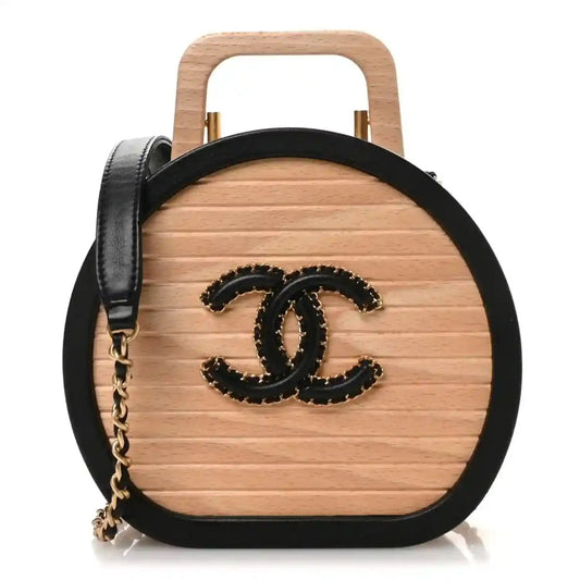 Chanel vanity case with round black CC logo on light wood front and black leather trim