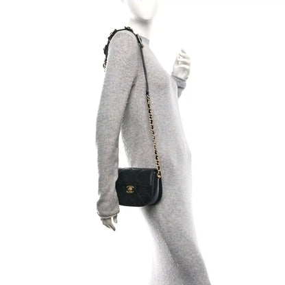 Black mini crossbody bag on chain strap with quilted design and small logo emblem