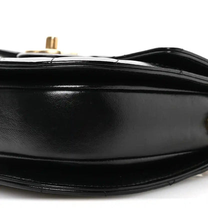 Black leather bag bottom edge with stitching and gold-tone post on top