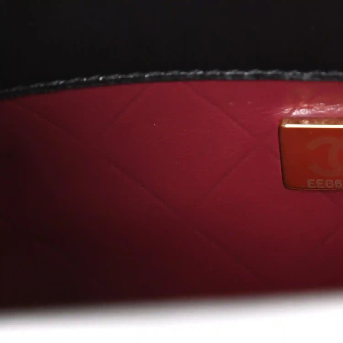 Red leather lining with rectangular authenticity label on black bag interior