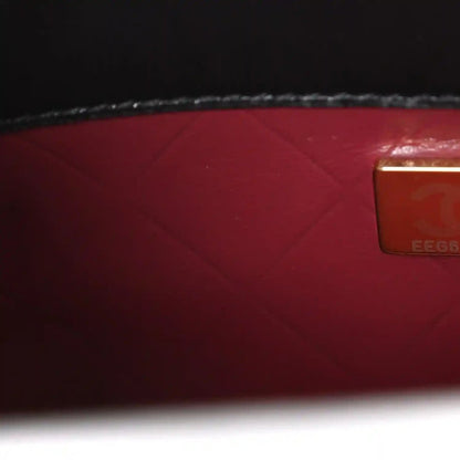 Red leather lining with rectangular authenticity label on black bag interior