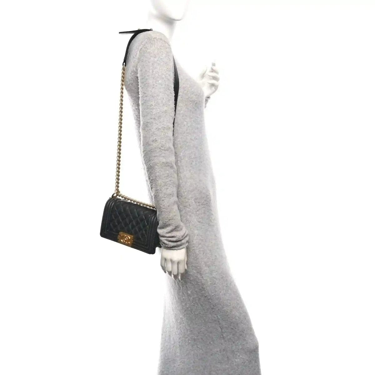 Small black quilted flap bag worn crossbody with gold-tone chain and front clasp