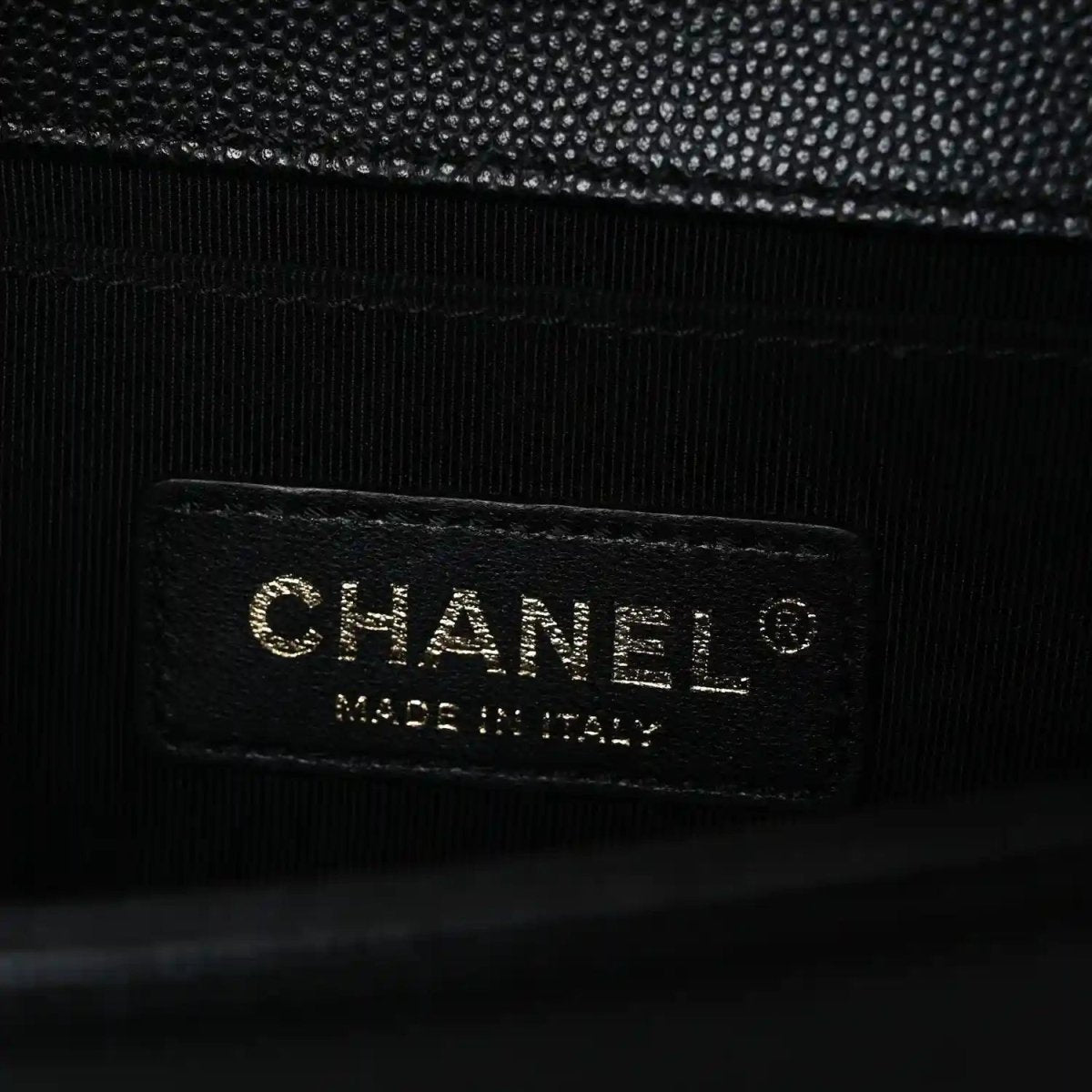 Black leather bag interior label with Chanel text and Made in Italy