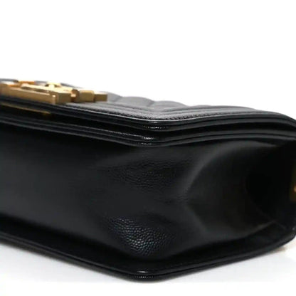 Black leather flap bag side with textured grain and stacked edge stitching