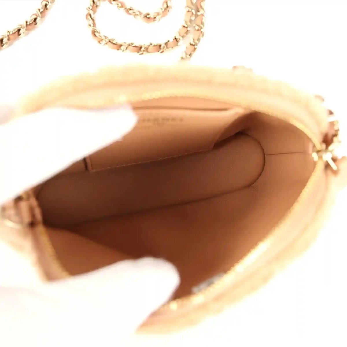 Beige crossbody bag interior with tan lining and top zipper opening