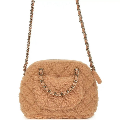 Beige shearling dome crossbody bag with gold chain, front CC hardware, and side tag