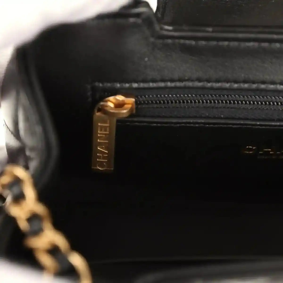 Chanel Kelly shopper bag close-up of black zipper pull with gold logo hardware
