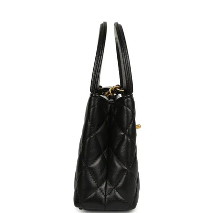 Chanel Kelly shopper bag in black quilted leather with side view and dual top handles