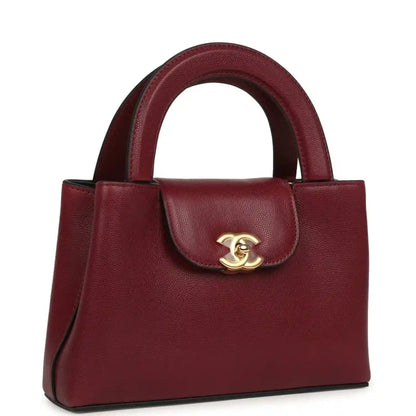 Dark burgundy caviar leather mini shopper bag with gold CC logo and structured top
