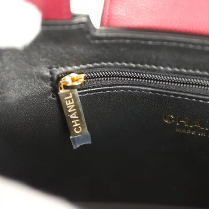 Dark interior zip pull tag with CHANEL logo on stitched leather pocket
