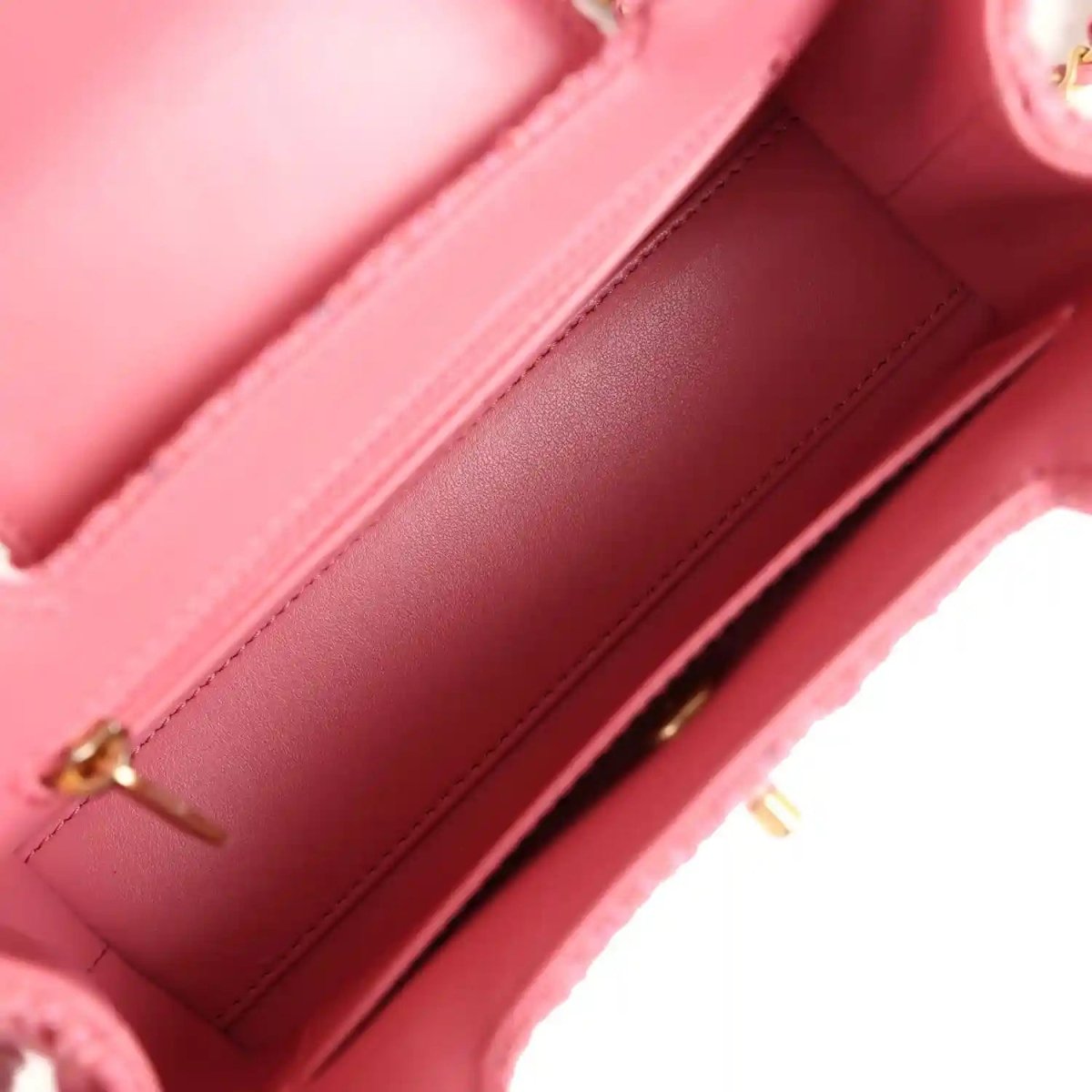 Pink leather interior with stitched edges and gold-tone zipper hardware