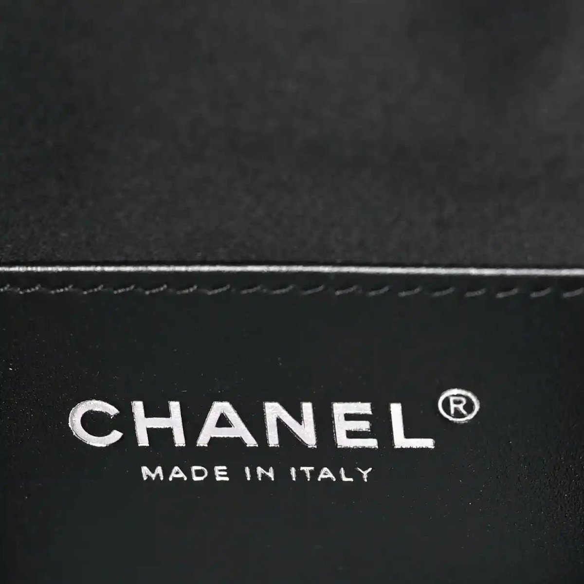 Chanel logo and “MADE IN ITALY” on black leather handbag surface