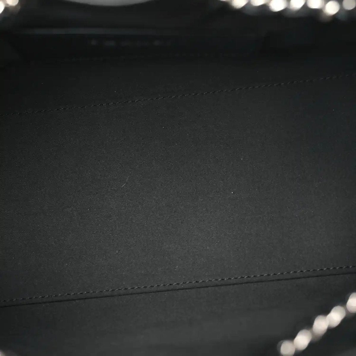 Black quilted leather handbag panel with visible stitching detail