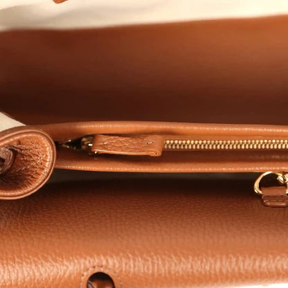 Chanel small tote bag interior close-up with gold zipper pull and leather snap tab