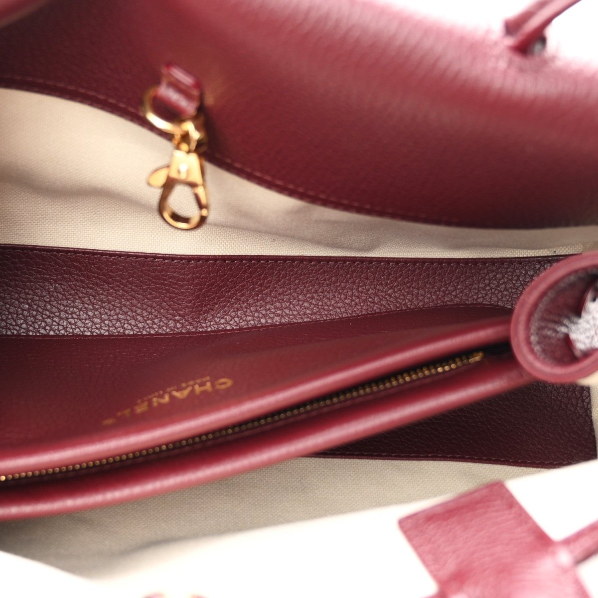 Chanel burgundy calfskin bag interior with zip edge and gold-tone clasp