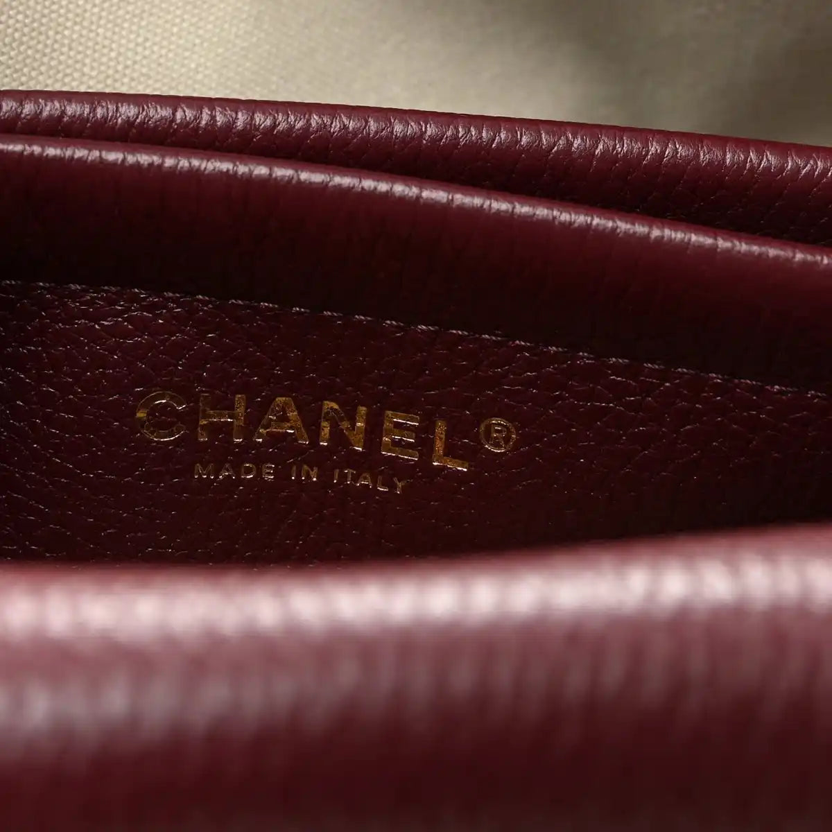 Burgundy leather label with CHANEL and “Made in Italy” text