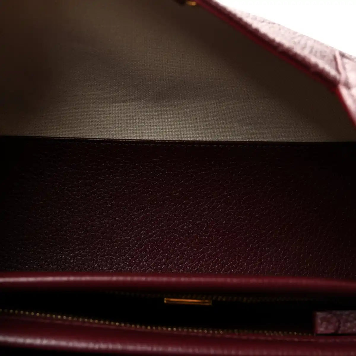 Burgundy leather interior with beige lining and zippered opening