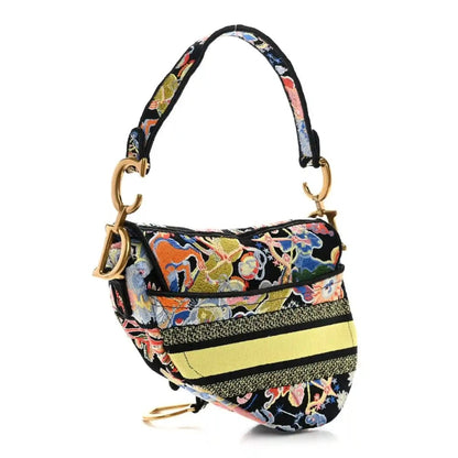 Embroidered canvas saddle bag with top handles, gold hardware; multicolor floral-zodiac motif