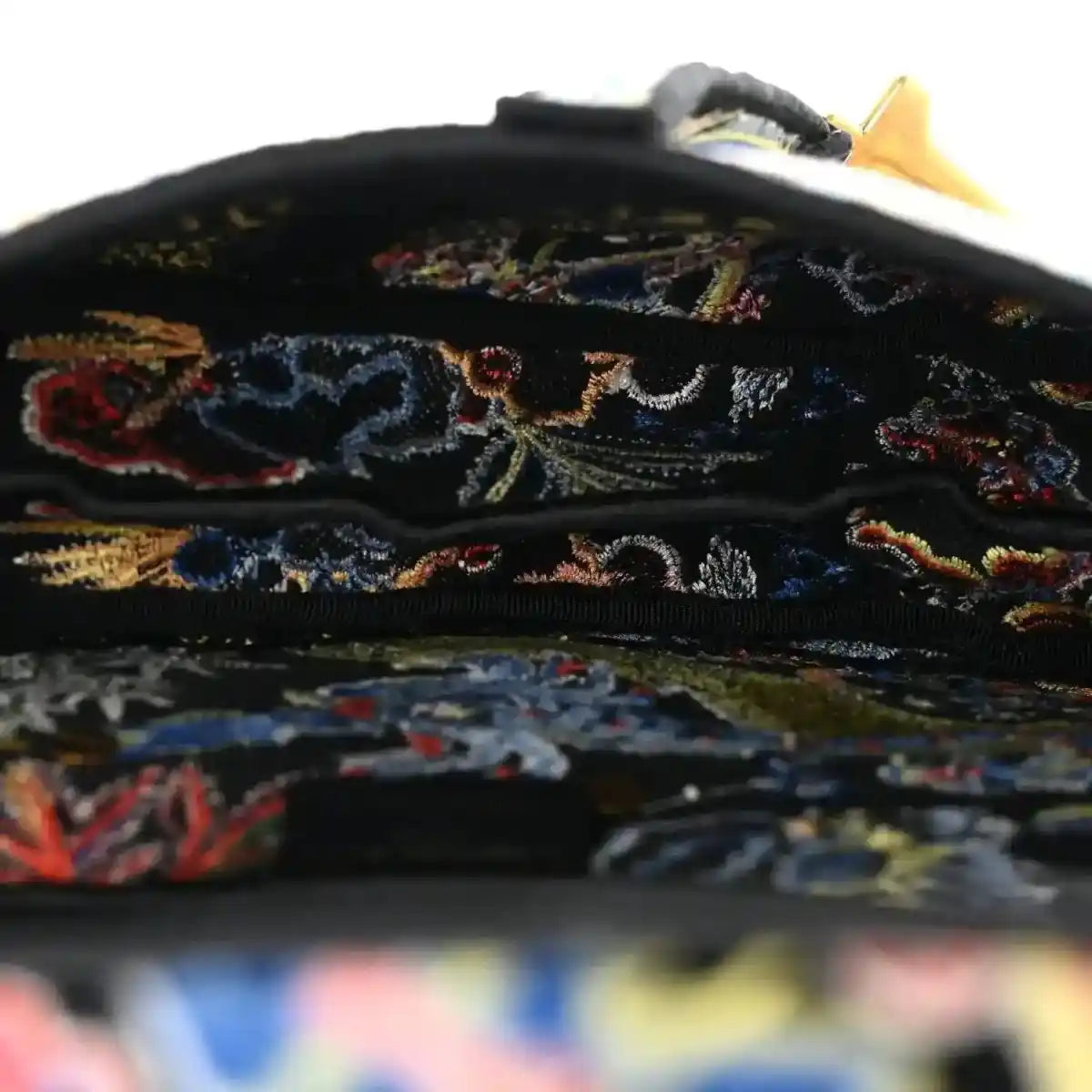 Black embroidered canvas interior flap edge with multicolor zodiac stitching