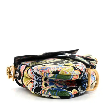Embroidered canvas saddle bag with rolled flap and gold hardware, multicolor zodiac pattern