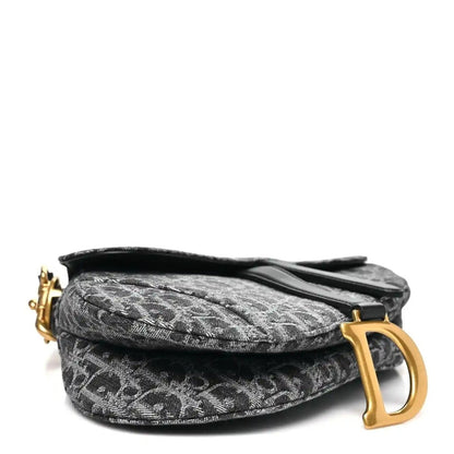 Black jacquard saddle bag with flap and large gold-tone D-shaped charm