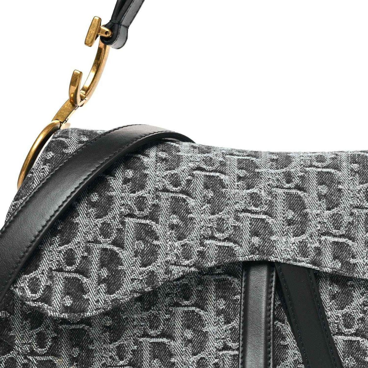 Black jacquard saddle bag flap with gold-tone clasp and strap attachment