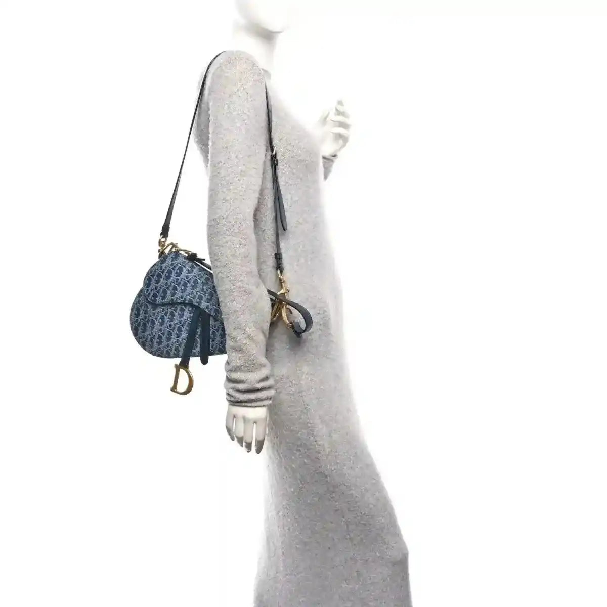 Dark blue jacquard saddle bag with gold hardware and shoulder strap, side view