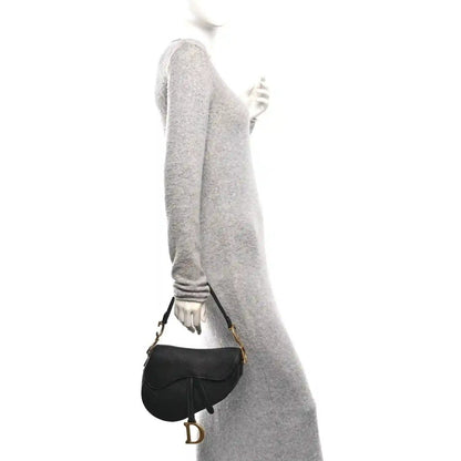 Christian Dior black grained calfskin saddle bag worn crossbody with gold-tone D buckle